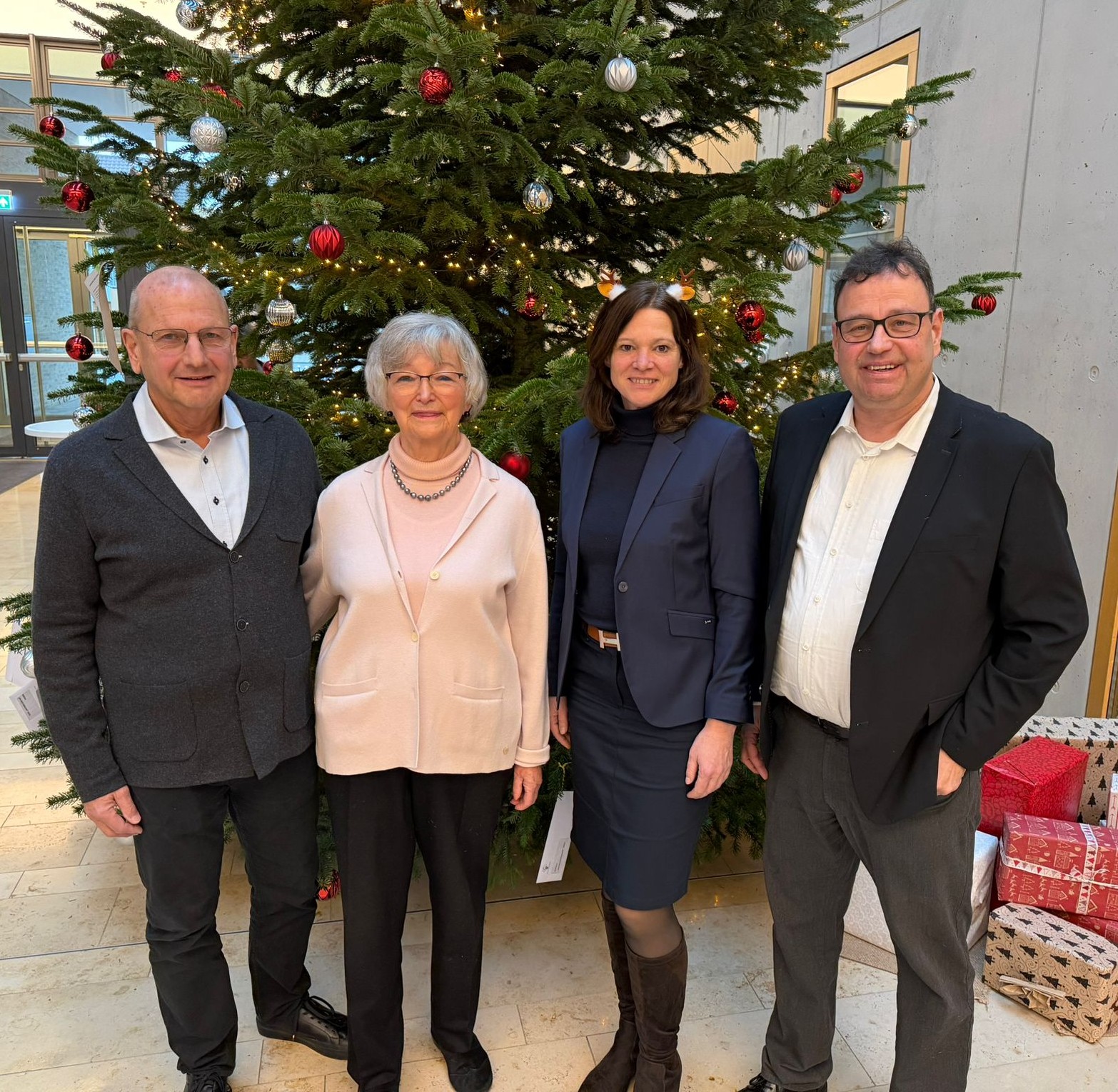 4 Personen vor Weihnachtsbaum