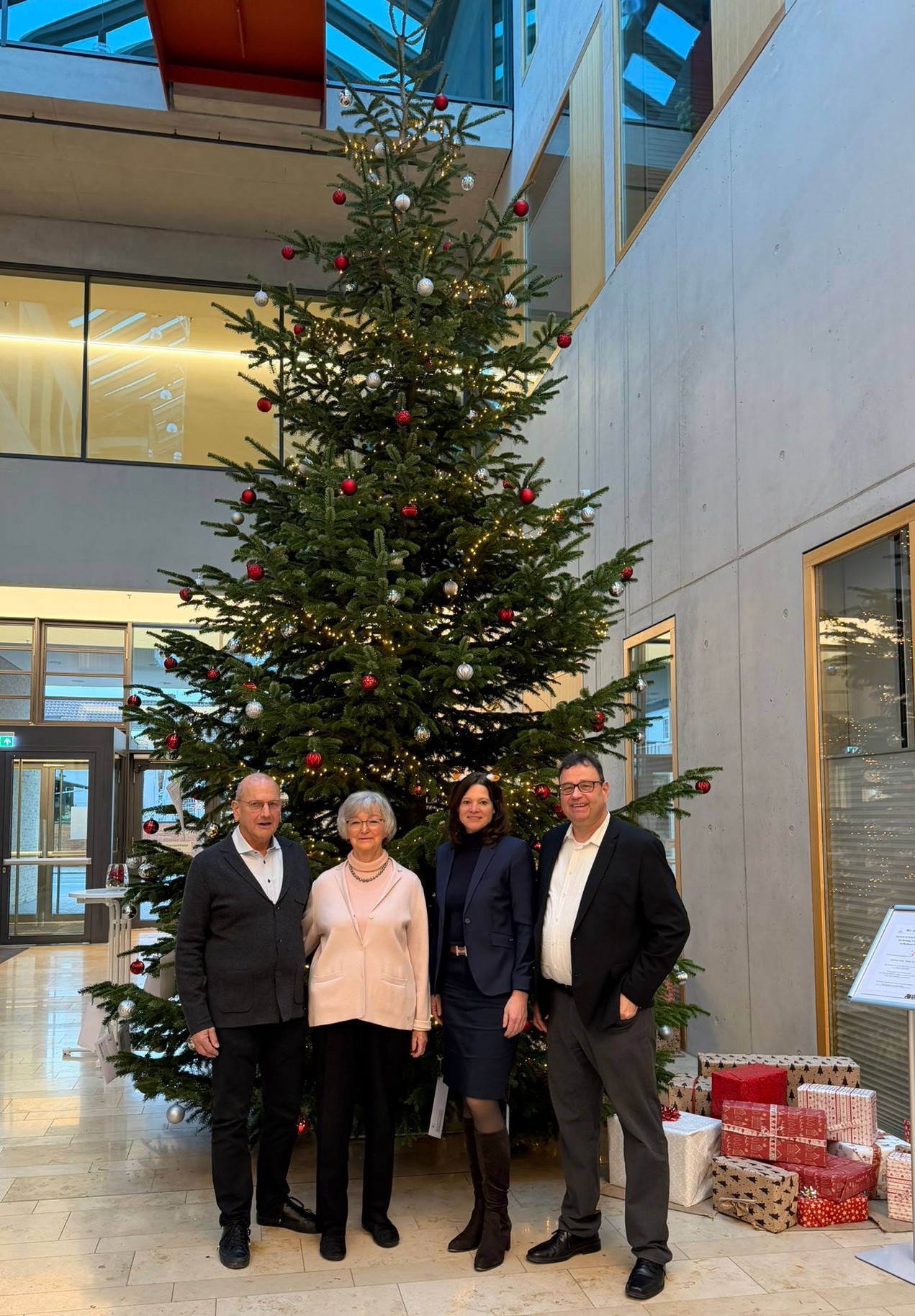 4 Personen vor Weihnachtsbaum